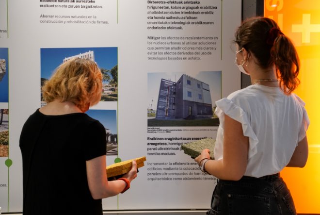 Dos mujeres mirando un panel de la exposición permanente del museo cemento rezola